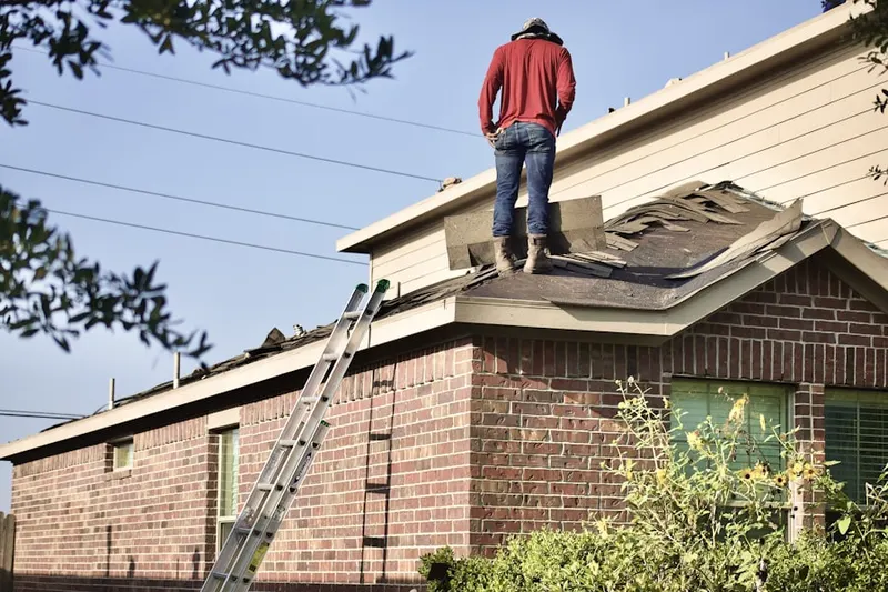 Professional roofer working on a residential roof in Kings Manor